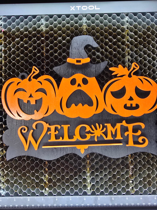 Halloween Türschild „Welcome“ mit drei Kürbisgesichtern